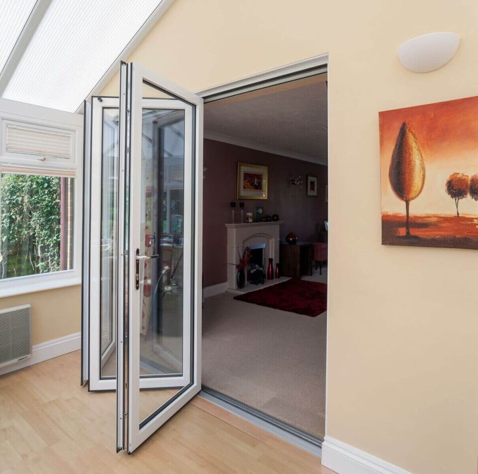 White bifold doors between a conservatory and living room