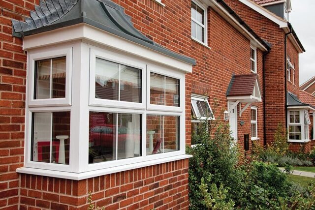 White PVCu bay window with Georgian bars on a red brick house