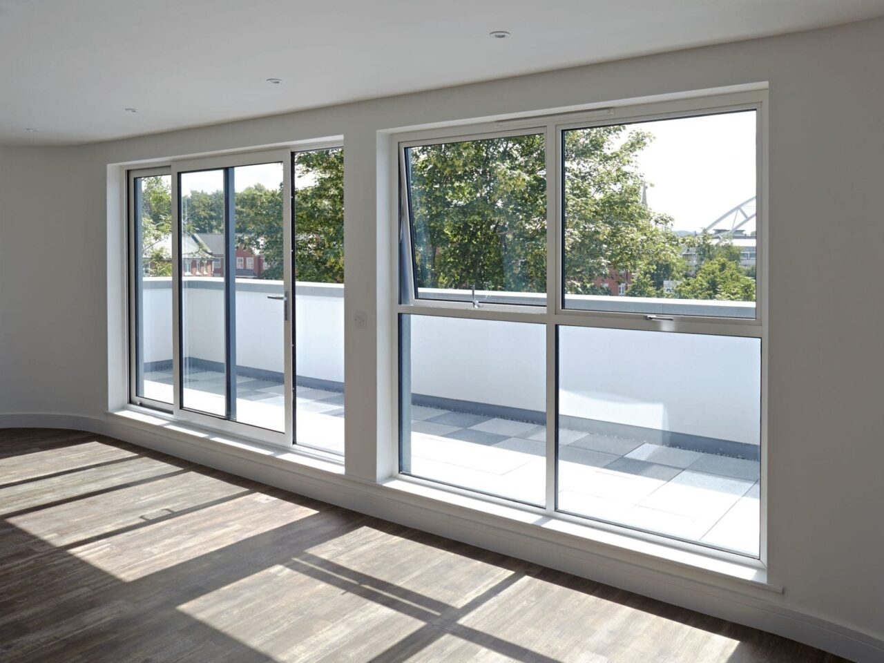 Slim grey aluminium sliding doors and windows in a bright new-build room